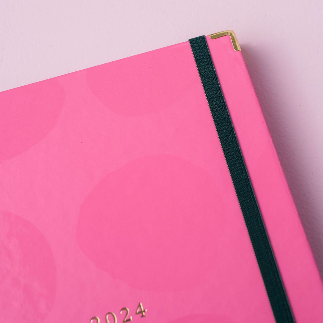 detalhe da cantoneira do Planner 2024 Rosa Nuvem meg & meg sobre fundo rosa claro