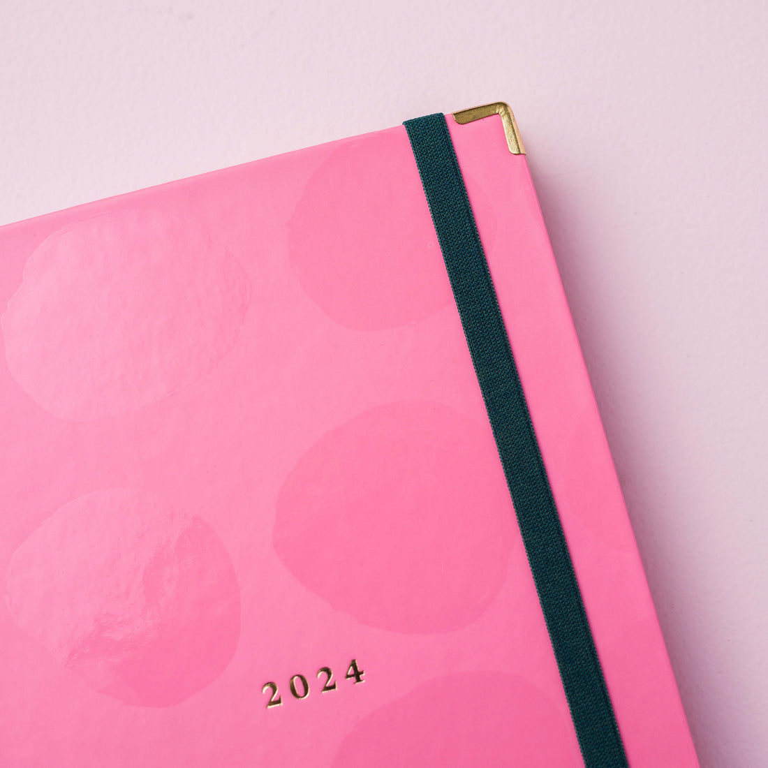 detalhe da cantoneira do Mini planner 2024 rosa nuvem meg & meg sobre fundo rosa claro