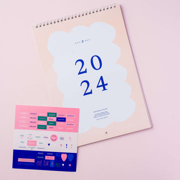 calendário de parede 2024 com cartela de adesivos sobre fundo rosa claro