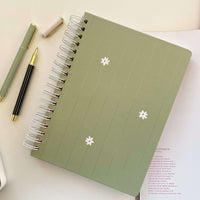 caderno universitário pautado com capa verde com margarida