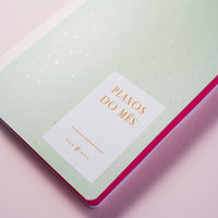 detalhe do verniz da capa do caderno de planejamento mensal sobre fundo liso rosa