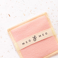 quadradinho de tecido com tag de algodão cru da marca meg & meg para passar produtos de skincare