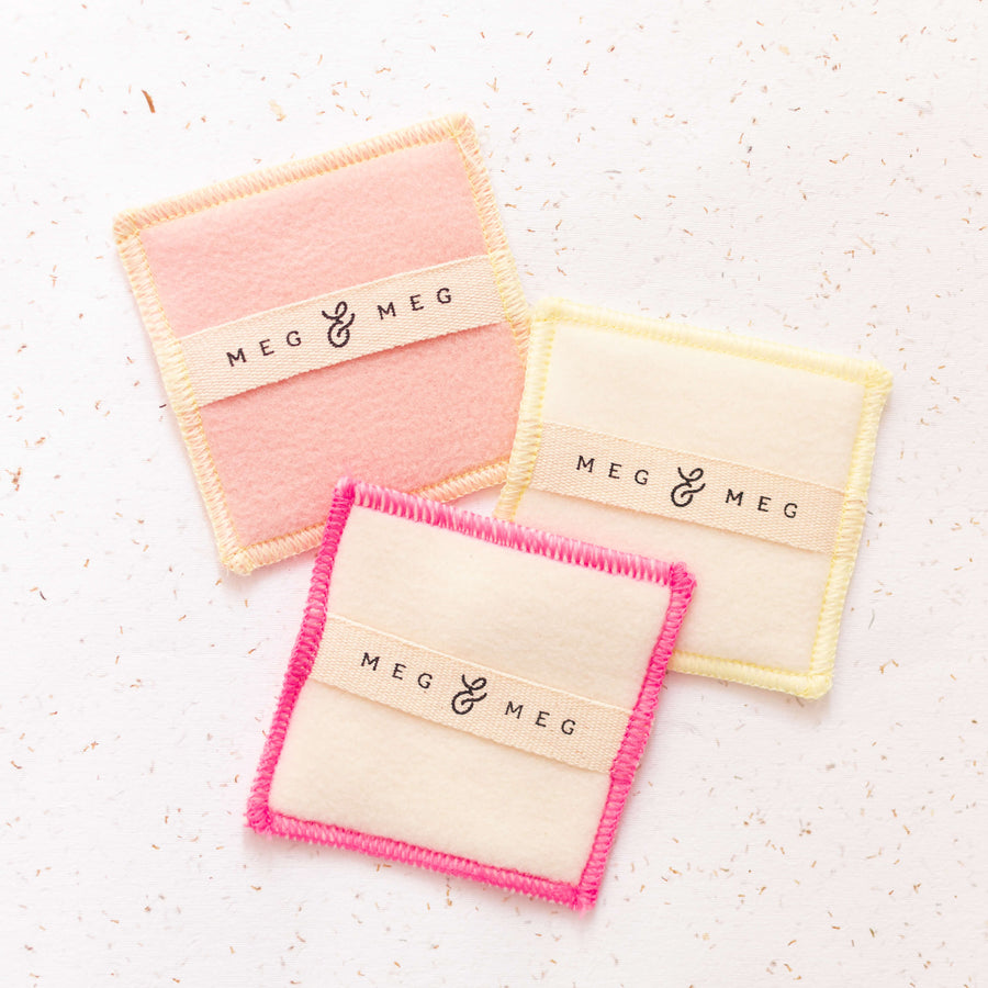 3 quadrados de tecido com tag de algodão cru da marca meg & meg para passar produtos de skincare